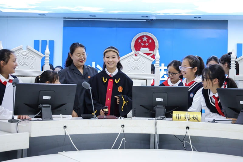 281779931791413653.jpg 王雨璠摄 5月26日,同学们在新沂法院少年法庭审判席前试穿法袍、敲响法槌,从“第一视角”体验审判的庄严与责任.jpg